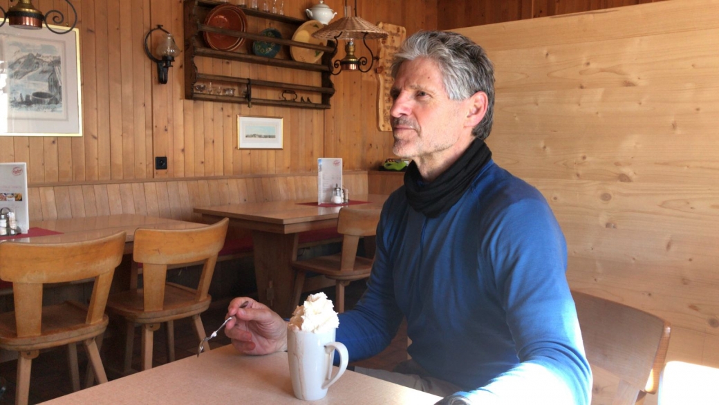 Stefano à l'intérieur du Berghotel Faulhorn, en train de déguster un chocolat chaud.